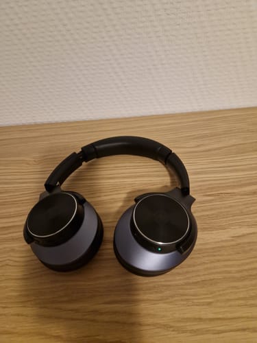 Black Oneodio headphones on a wooden surface